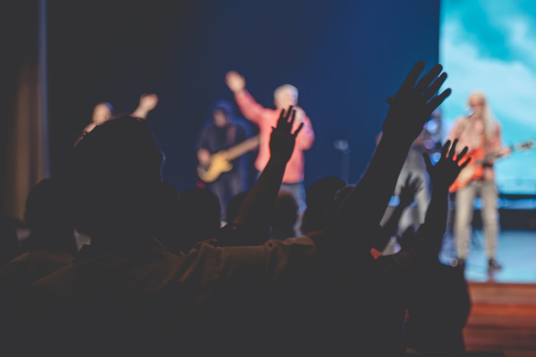 About people-raising-their-hands-in-front-of-crowd-pgkczxkua6c